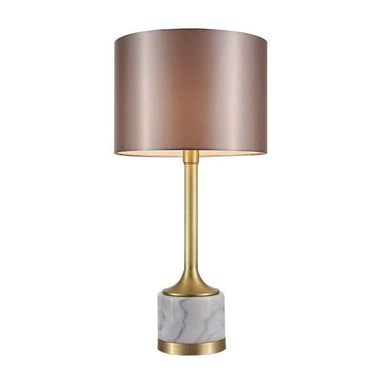 Lampe à poser : abat-jour tissu beige rosé, monture dorée et base en marbre blanc veinuré.