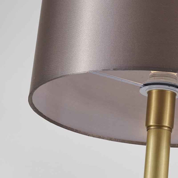 Lampe à poser : gros plan sur l’abat-jour tissu beige rosé et le pied doré au marbre blanc.