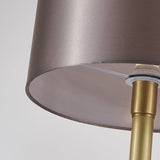 Lampe à poser : gros plan sur l’abat-jour tissu beige rosé et le pied doré au marbre blanc.