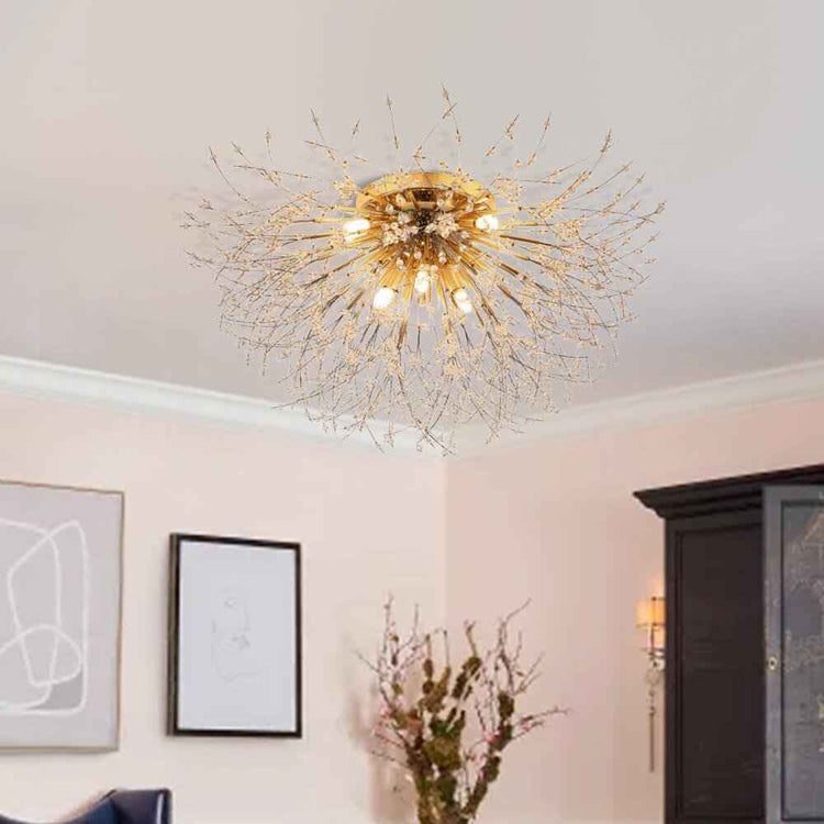 Plafonnier moderne doré sputnik au plafond, structure filigrane et petites perles, ampoules visibles.