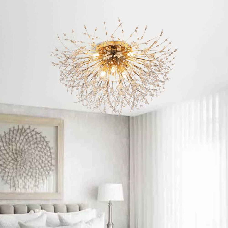 Plafonnier moderne doré sputnik au plafond, structure filigrane avec perles, lumière chaude.
