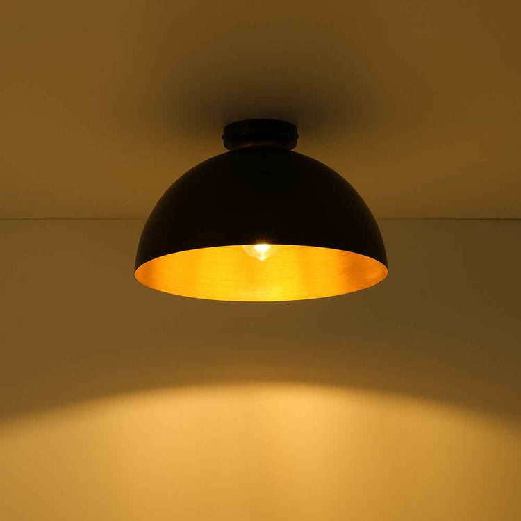 Plafonnier dôme noir à intérieur doré, 1 ampoule allumée, vue rapprochée.