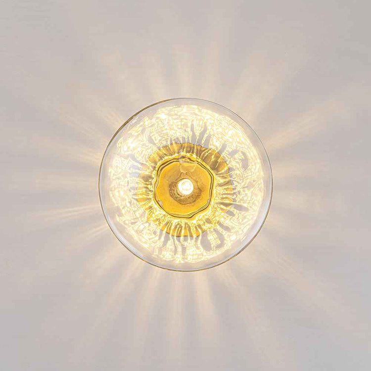 Plafonnier ovale en verre transparent, monture laiton et culot central, lumière chaude.