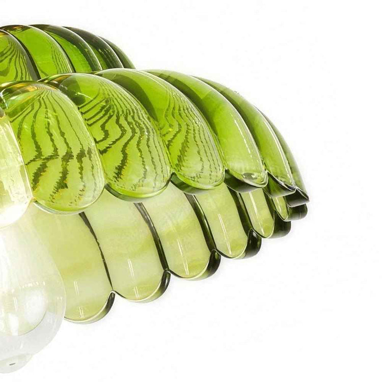 Abat-jour bombé en verre vert nervuré, rangée de coupelles translucides.
