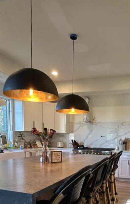 Suspension dôme métallique noir avec intérieur doré allumé