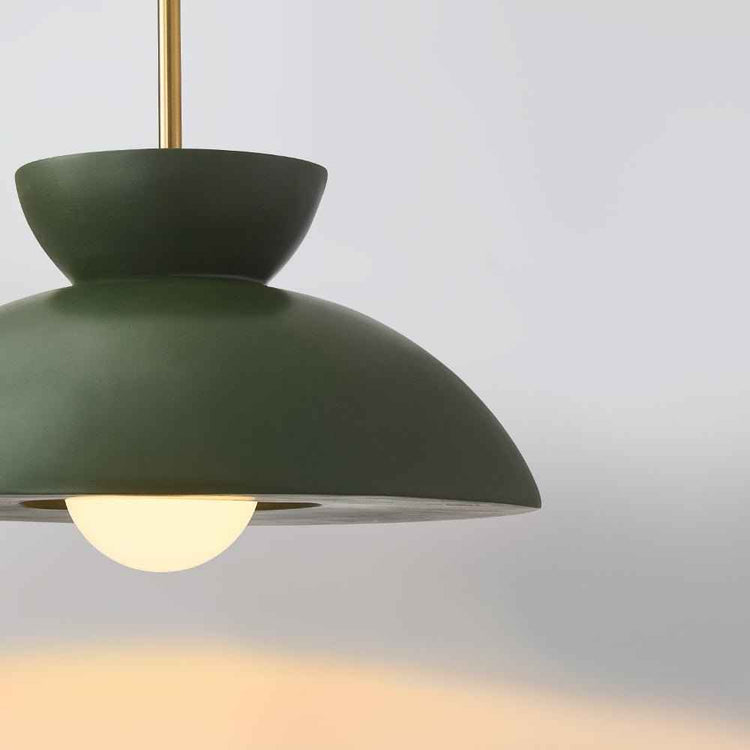 Suspension dôme verte en gros plan, abat-jour bombé avec tige dorée et lumière.