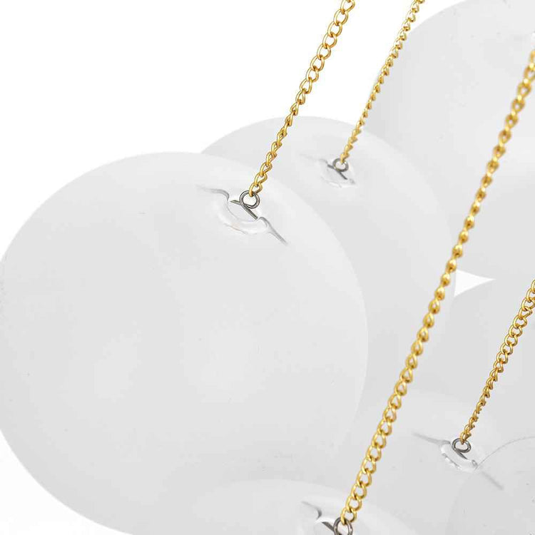 Grappe de luminaires suspendus avec boules en verre blanches et chaînes dorées